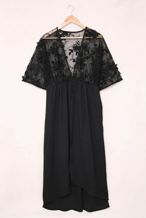 Black dress with lace detailing on a hanger against a white background