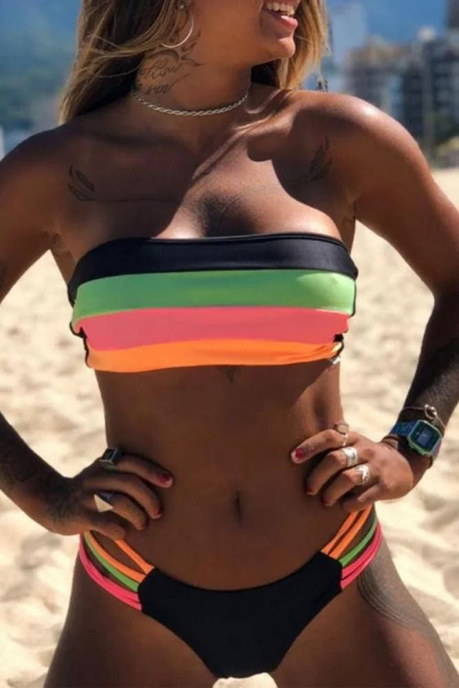 Woman wearing a colorful striped bikini on a beach.